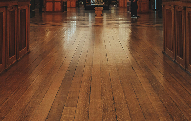 Piso de madera histórico pulido con reflejos en interior de museo
